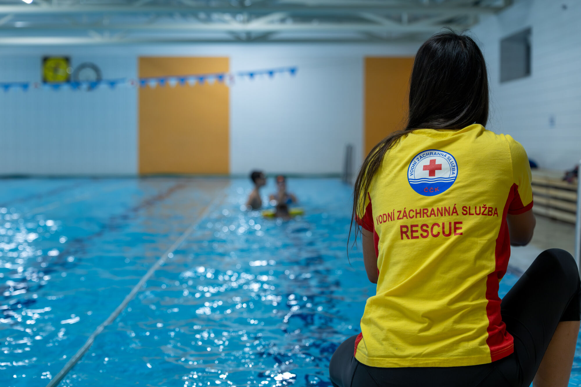 Ilustrační foto trenéra v&nbsp;oblečení VZS ČČK na&nbsp;bazéně.